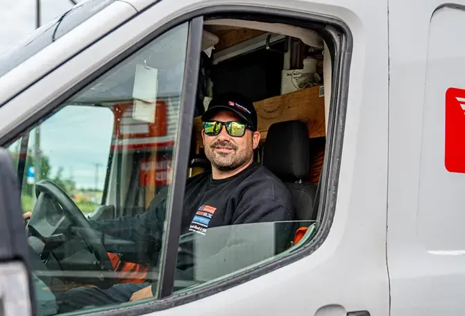 Installeur porte de garage dans son camion travail
